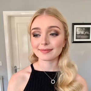 Client taking an after picture showing their flawless makeup and hair – A beautiful transformation by KT Beauty for a perfect, long-lasting look.